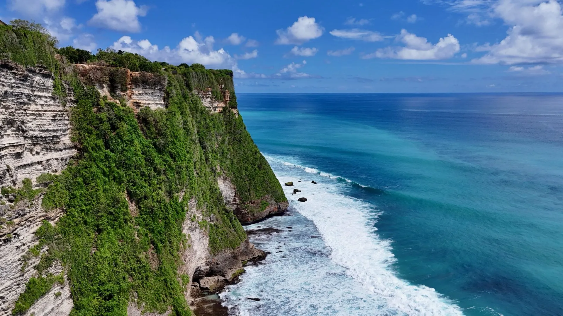 Limestone cliffs dropping into turquoise water along the Uluwatu coast